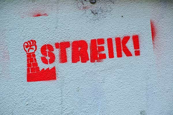 Graffiti in grellem Rot, eine erhobene Faust, daneben das Wort "Streik"